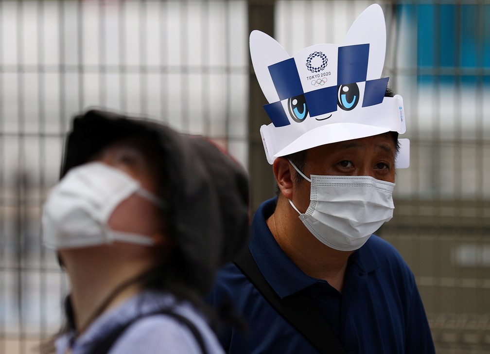 Pessoas usam máscara em frente ao Estádio Nacional em Tóquio, no Japão, nesta terça-feira (3) — Foto: Kim Kyung-Hoon/Reuters