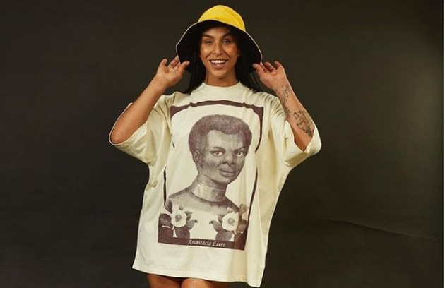 Linn da Quebrada usou uma camisa com a mensagem 'Anastácia Livre', com a estampa do quadro do artista plástico Yhuri Cruz. A peça bombou nas redes (Foto: Reprodução)