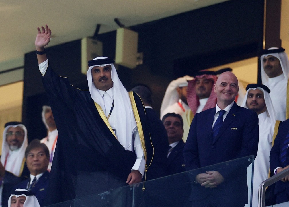 Tamim bin Hamad al-Thani, emir do Catar, acena ao lado do presidente da Fifa, Gianni Infantino, abertura da Copa neste domingo (20), em Doha — Foto: Kai Pfaffenbach/Reuters