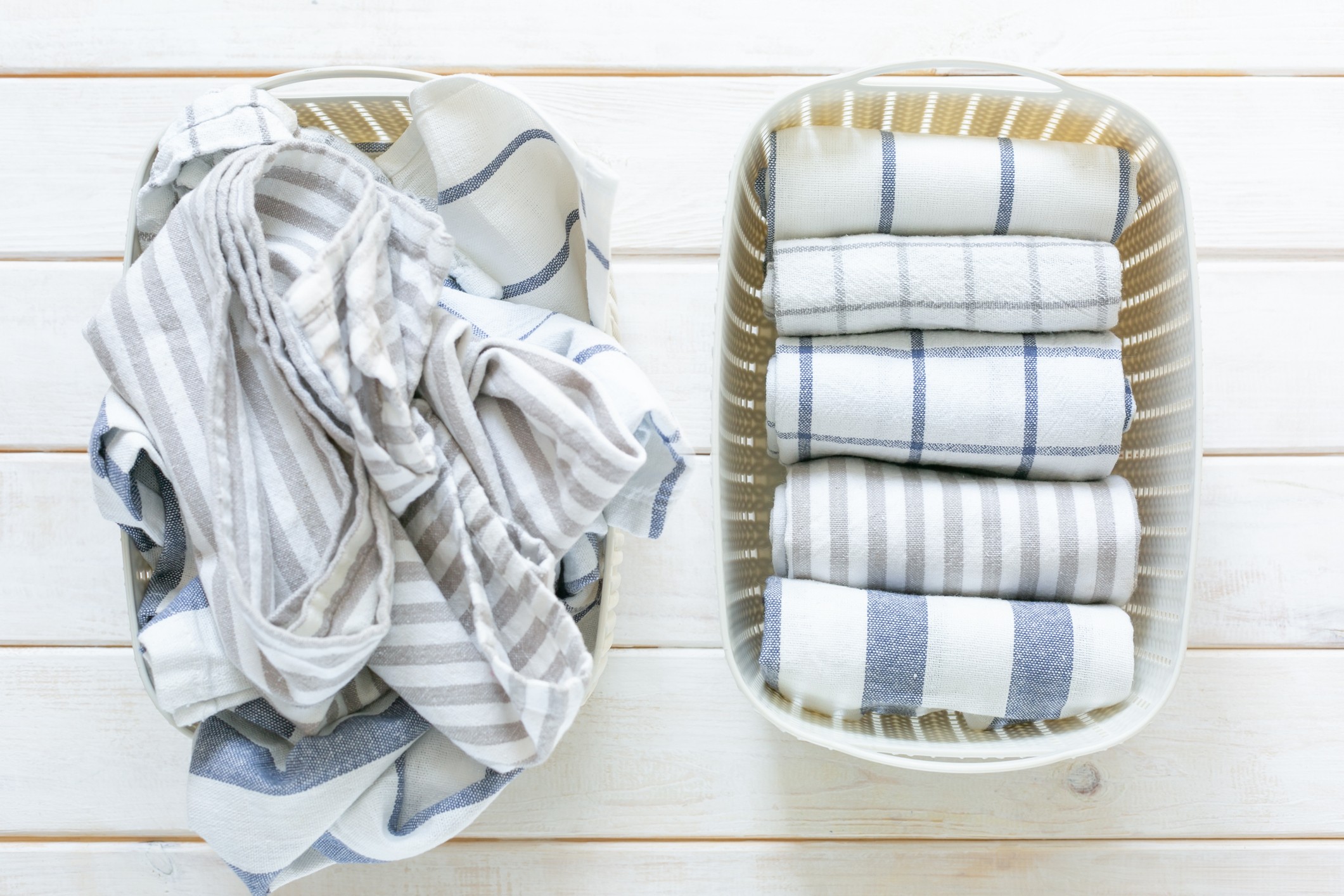 Marie Kondo tidying concept - folded kitchen linens in white basket, top view (Foto: Getty Images/iStockphoto)