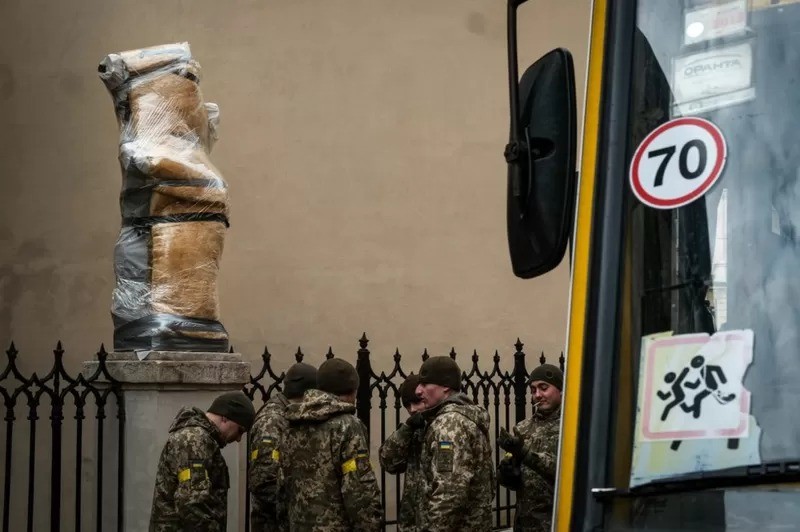 Soldados do lado de fora de uma igreja de Lviv onde estátuas foram protegidas (Foto: BBC)