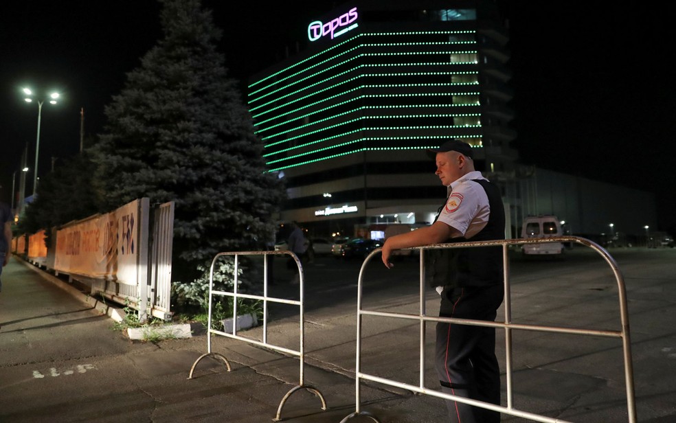 Policial cerca área em frente ao hotel Topos Congress, em Rostov-on-Don, na Rússia, após local ser evacuado por suposta ameaça de bomba, na noite de terça-feira (26) (Foto: Reuters/Marko Djurica)