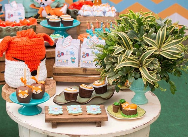 Mesa redonda de madeira rústica com doces no tema da festa e raposa de crochê (Foto: Karina Martini)