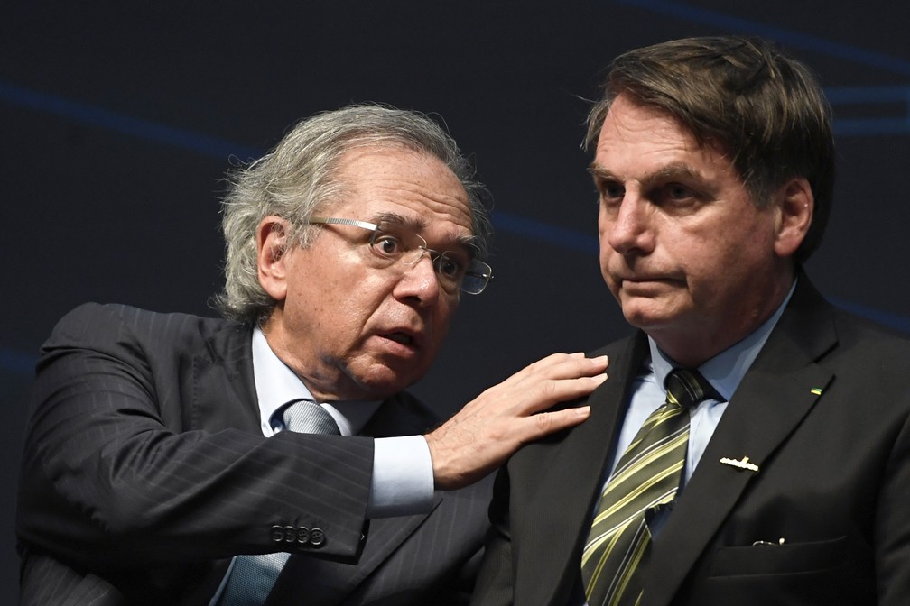 O ministro da economia Paulo Guedes e o presidente Jair Bolsonaro durante cerimônia no Rio de Janeiro, em outubro de 2019 — Foto: Mauro Pimentel/AFP