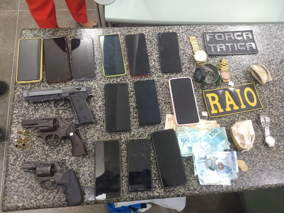 Polícia apreendeu 12 aparelhos celulares, armas, relógios e dinheiro que estavam com grupo que assaltou confecção em Fortaleza. — Foto: Polícia Militar/ Divulgação