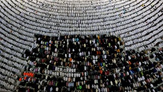 Fiéis muçulmanos rezam ao redor da Caaba, na Grande Mesquita, na cidade sagrada de Meca, na Arábia Saudita, onde um milhão de pessoas, – sendo aproximadamente 850.000 do exterior – podem participar do hajj deste ano, a peregrinação obrigatória – para os islâmicos em condições de viajar. A pandemia afetou o rito que é um pilar da religião — Foto: AFP