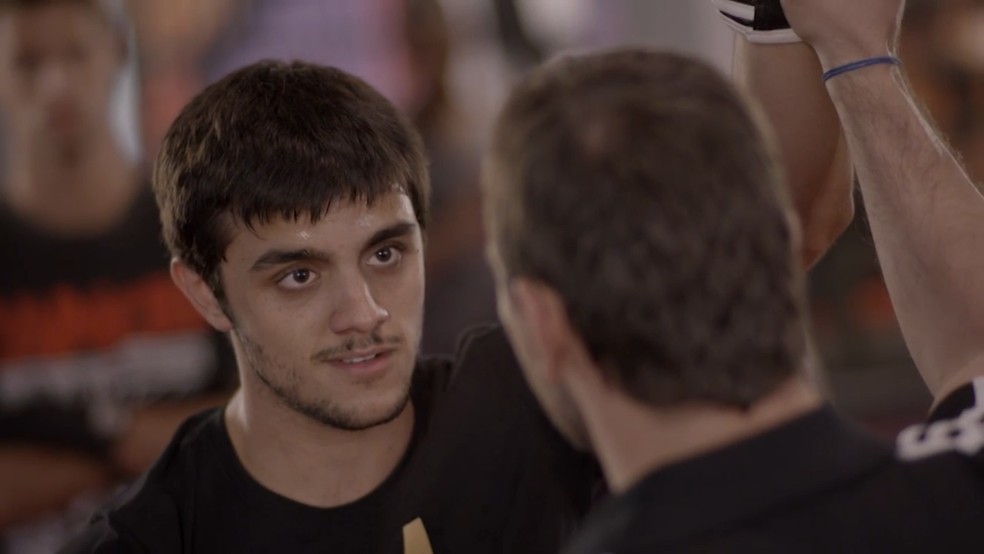 Cobra (Felipe Simas) é convencido por Lobão (Marcelo Faria) a lutar na Khan.  — Foto: Globo