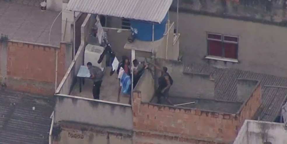 Homens armados tentam fugir durante operação da polícia em telhado no Jacarezinho, Zona Norte do Rio — Foto: Reprodução/TV Globo