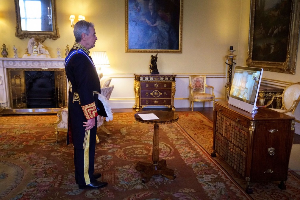 Rainha Elizabeth II (na tela do computador) em conferência com Jose Pascual Marco Martinez (à esquerda). — Foto: Victoria Jones/via REUTERS
