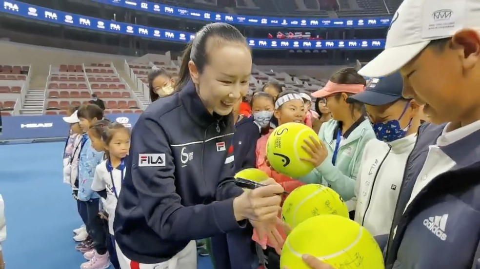 Peng Shuai assina bolas de tênis um torneio em Pequim