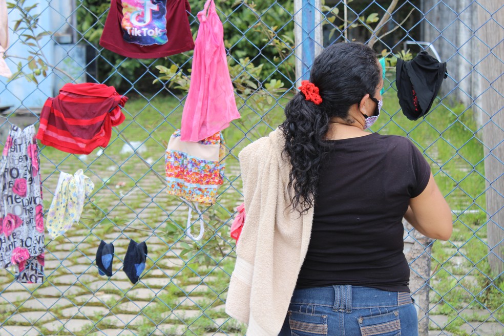 Pessoas estendem roupas em cercas improvisadas — Foto: Caíque Rodrigues/G1 RR