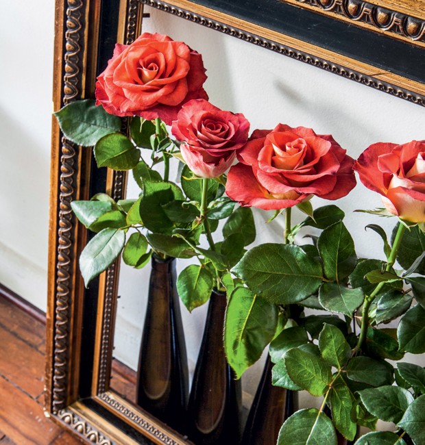 A moldura antiga, no chão, ficava vazia até ele colocar estes vasos com rosas de verdade. (Foto: Lufe Gomes/Life by Lufe)