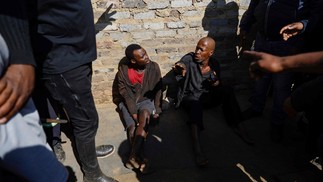 Suspeitos de garimpo ilegal são encurralados por membros da comunidade enquanto protestam contra a prática e o aumento do crime na área de Kagiso, área de Joanesburgo, capital da África do Sul  — Foto: GUILLEM SARTORIO / AFP