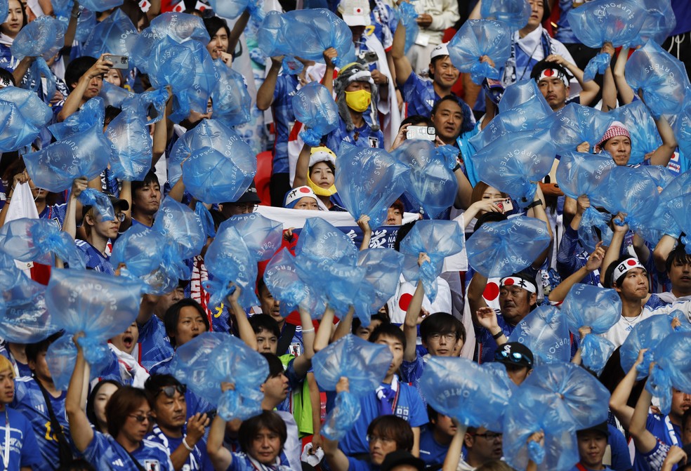 Torcedores do Japão com sacos vazios para recolher lixo em Japão x Costa Rica — Foto: Reuters