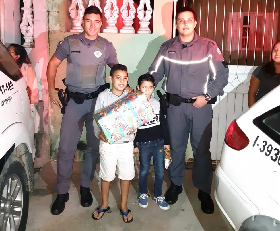 Policiais ao lado de João Victor em frente à sua casa, em São Vicente, SP (Foto: Divulgação/Polícia Militar)