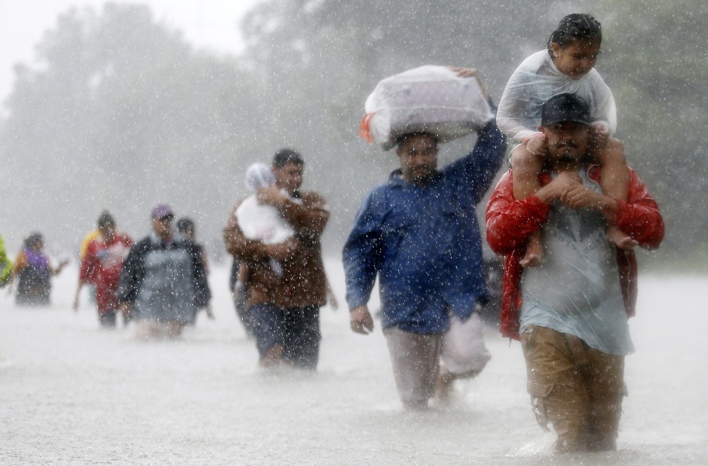  Moradores atravessam as águas de inundação após passagem do furacão Harvey em Beaumont Place, em Houston, no Texas (Foto: Jonathan Bachman/Reuters)