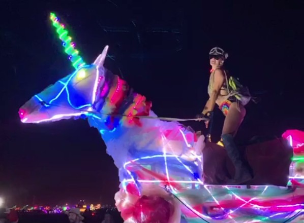 A socialite Paris Hilton dançando em cima de um unicórnio gigante durante o festival Burning Man (Foto: Instagram)