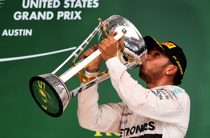 Lewis Hamilton bebe champanhe no troféu para celebrar vitória no GP dos EUA e título mundial  (Foto: AFP)