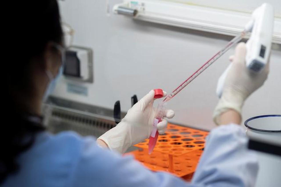 Cientista realiza teste para identificar pacientes com coronavírus em universidade de Pequim. — Foto: Thomas Peter/Reuters