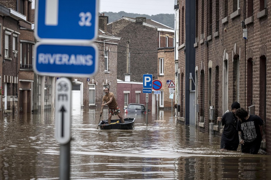 Eventos climáticos: homem rema em rua residencial após enchente em Angleur, Liege, na Bélgica