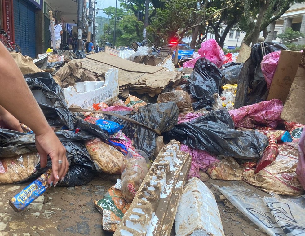 Jovem recolhe produtos do lixo após chuvas em Petrópolis — Foto: Matheus Rodrigues/g1 Rio