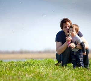 Pai e filho brincando de bolhas de sabão ao ar livre (Foto: Shutterstock)