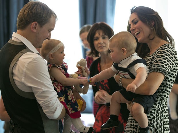 O príncipe George, no colo da mãe, Kate, brinca com outro bebê na Nova Zelândia (Foto: Woolf Crown Copyright/AFP)