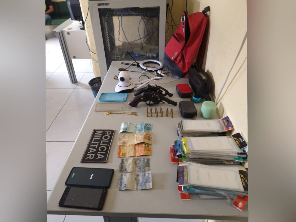 PM apreendeu com os suspeitos de assalto dois revólveres municiados, dinheiro em espécie e produtos roubados.  — Foto: Polícia Militar/ Divulgação