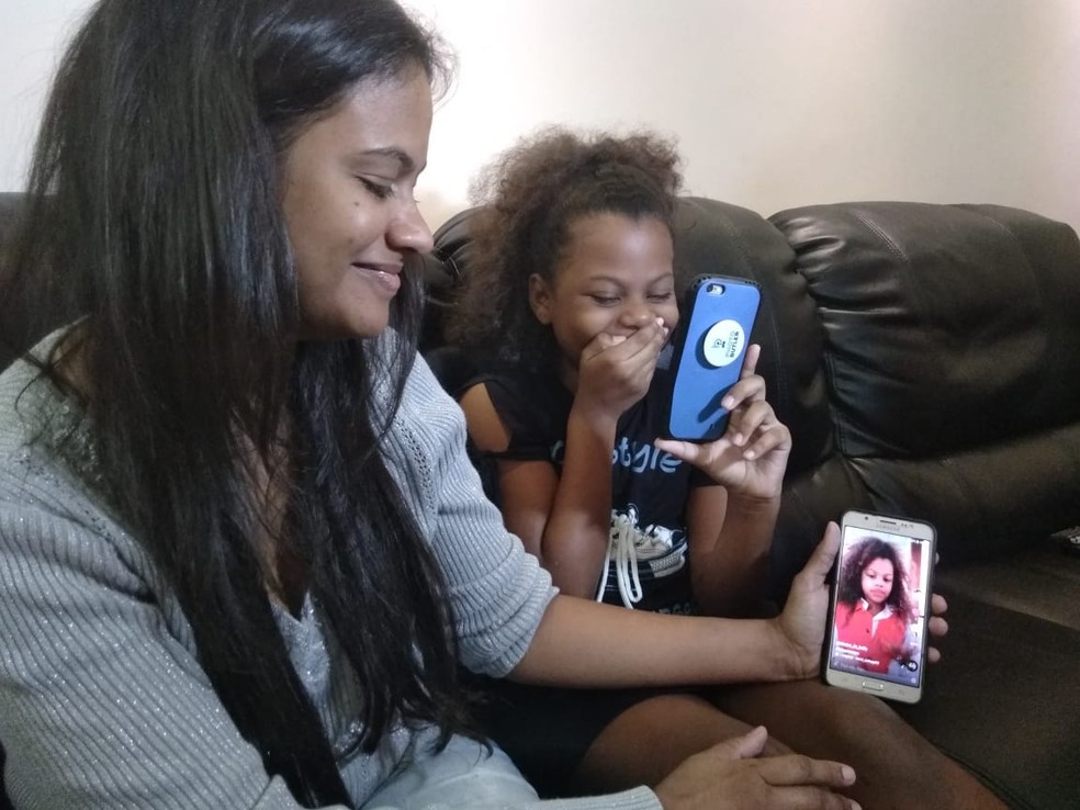 Mãe mostra orgulhosa fotos da filha, enquanto Izabella se espanta com número de curtidas recebidas (Foto: Zana Ferreira/G1)