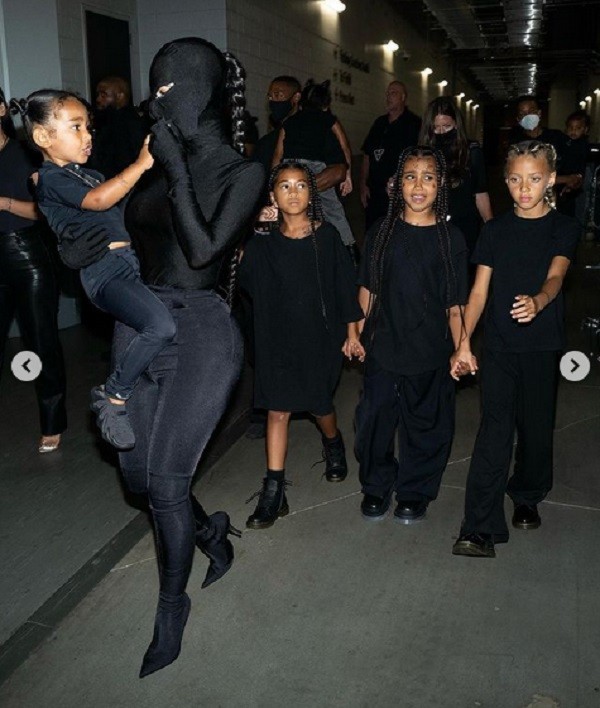 Kim Kardashian com uma máscara preta no rosto e na companhia dos filhos antes do início do show de Kanye West (Foto: Instagram)