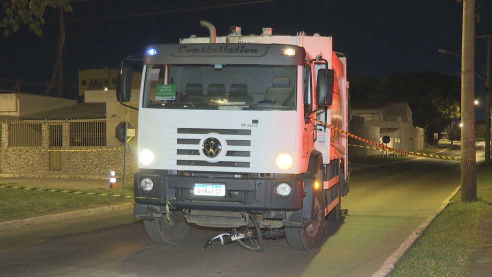 Bicicleta foi parar sob caminhão de lixo após ciclista ser atropelado e morto, no DF — Foto: TV Globo/Reprodução