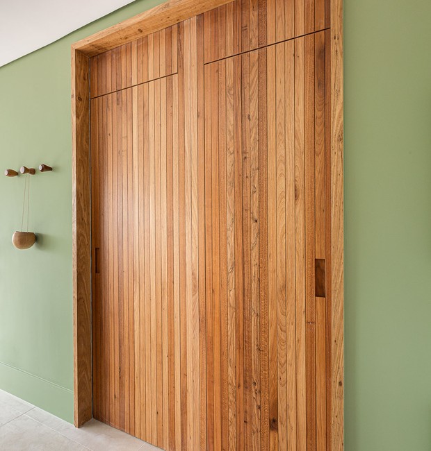 Lavabo e lavanderia | Quando fechadas, as portas parecem um único painel de madeira. Cabideiro Fernando Jaeger (Foto: Gisele Rampazzo / Divulgação)