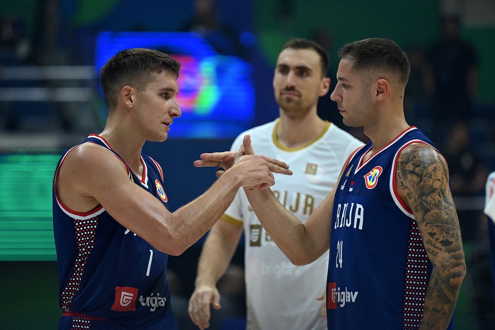 Bogdanovic e o jovem Jovic se cumprimentam em jogo da Sérvia — Foto: JAM STA ROSA / AFP