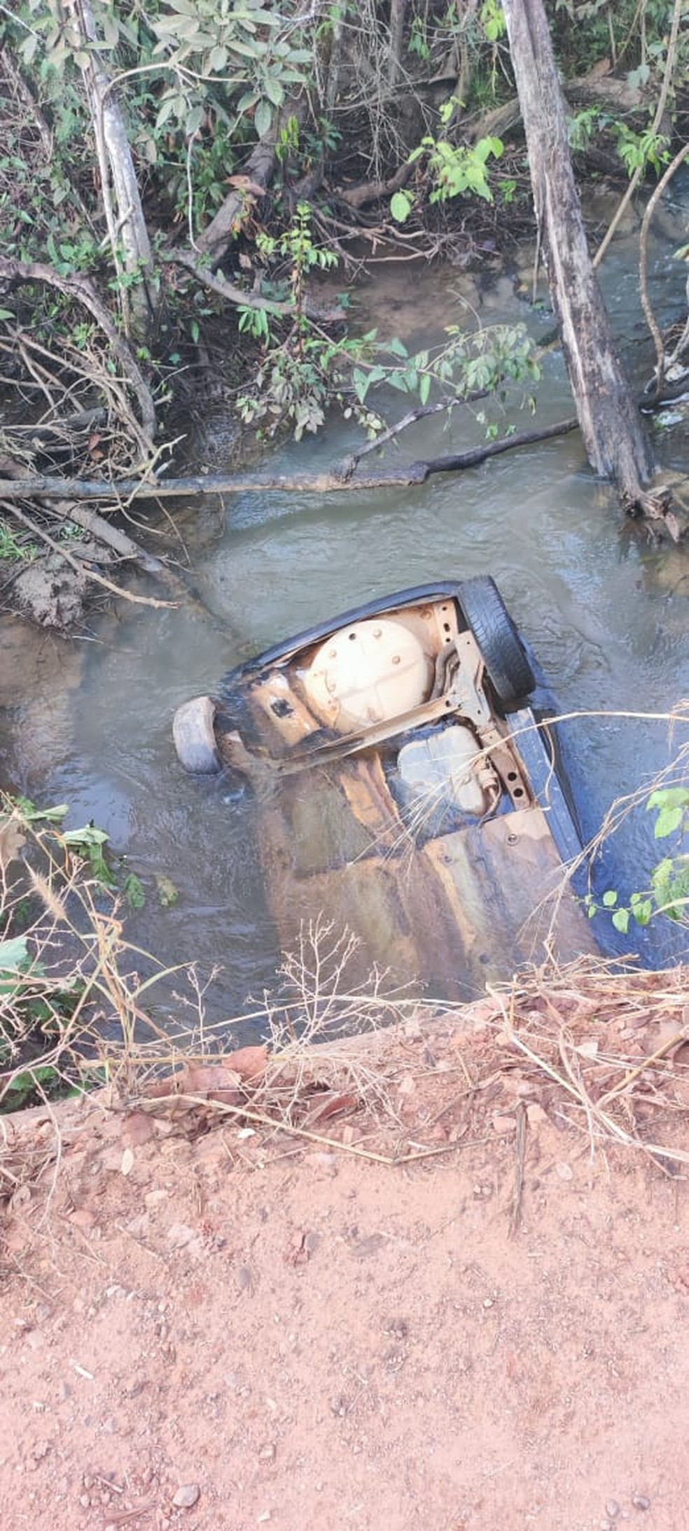 Veículo estava dentro do córrego com as rodas para cima.  — Foto: Cedida. 