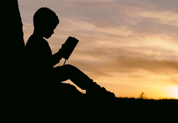 Leitura menino lendo livro (Foto: Aaron Burden no Unplash)
