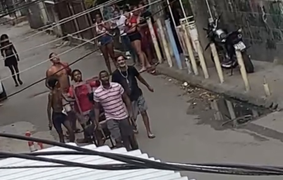 Moradores carregam vítima de tiroteio na Nova Holanda, comunidade do Complexo da Maré