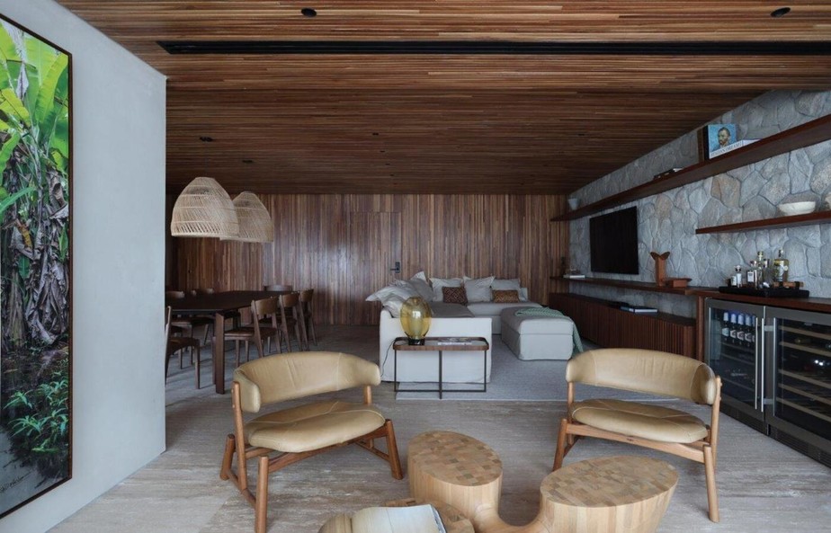 LIVING | No estar, a mesa de centro de Jader Almeida confere design contemporâneo e sintetiza o conceito do apê, trazendo rusticidade, leveza e sofisticação. Poltronas são da Dpot e obra de arte de Kiolo