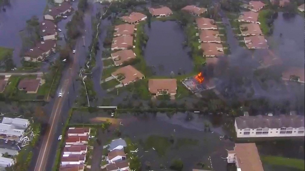 Imagem área mostra incêndio e casas inundadas após a passagem do furacão Ian na Flórida, EUA — Foto: WPLG TV via ABC via REUTERS