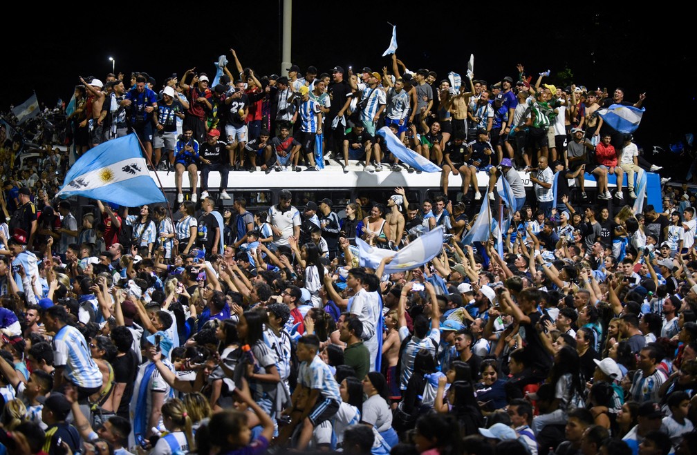 Torcedores argentinos se aglomeram do lado de fora da sede da Associação de Futebol Argentino, em Buenos Aires, antes da chegada do ônibus da seleção campeã mundial, no dia 20 de dezembro de 2022 — Foto: Mariana Nedelcu/Reuters