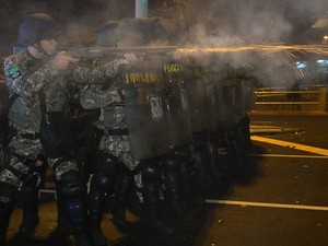 Policiais atiram contra grupo de manifestantes (Foto: Yasuyoshi Chiba/AFP)