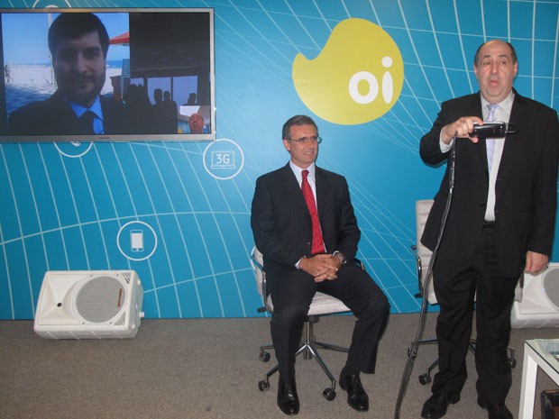 O presidente da Anatel, João Batista Rezende, faz uma cideochamada na rede 4G para um diretor da Oi que estava fora do prédio. O presidente da Oi, Francisco Vallim, sentado, assite à videochamada. (Foto: Lilian Quaino/G1)