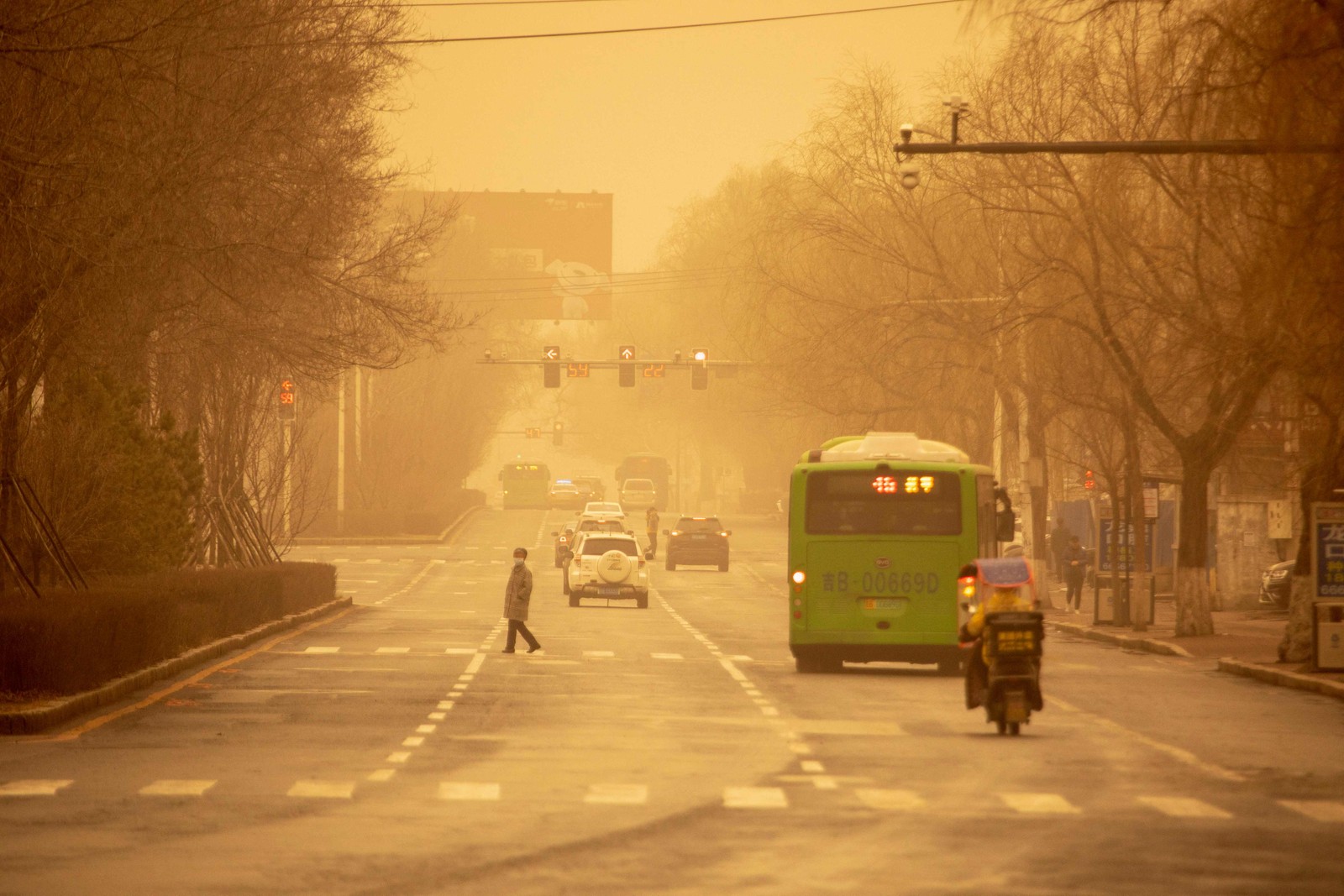 Pessoas caminham durante uma tempestade de areia em Jilin, na província de Jilin, no nordeste da China, em 22 de março de 2023 — Foto: AFP