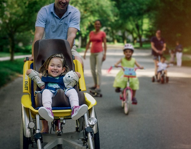 O sorriso genuíno de uma garota passeando em um carrinho adaptado. (Foto: Kate T. Parker)