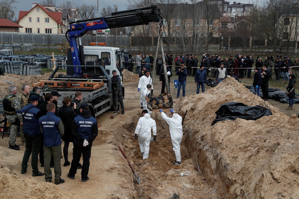 Funcionários exumam corpos de vala comum na cidade de Bucha, na Ucrânia, em 8 de abril de 2022 — Foto: Valentyn Ogirenko/Reuters