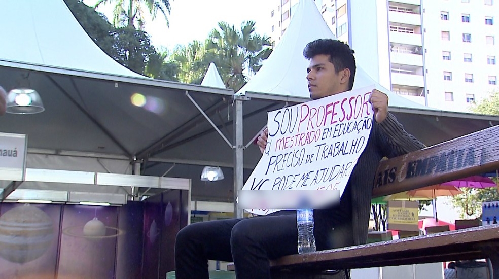 Victor Oliveira leva cartaz à Feira do Livro para tentar oportunidade de trabalho — Foto: Chico Escolano/EPTV