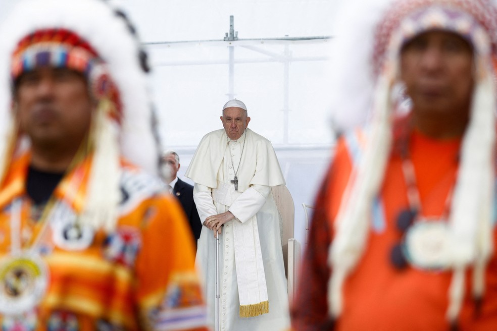 Papa Francisco aparece ao fundo diante de líderes indígenas do Canadá — Foto: Guglielmo Mangiapane/REUTERS