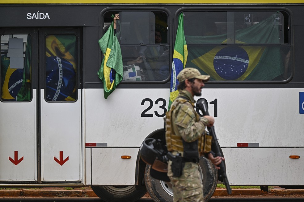 Bolsonaristas detidos são levados de ônibus para a sede da PF após participação nos atos criminosos do dia anterior — Foto: Mauro Pimentel/AFP