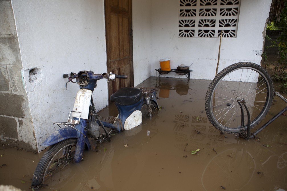 Uma moto e uma bicicleta são vistas parcialmente submersas em região alagada após passagem do furacão Irma, em Fort-Liberte, no Haiti (Foto: Dieu Nalio Chery/AP)