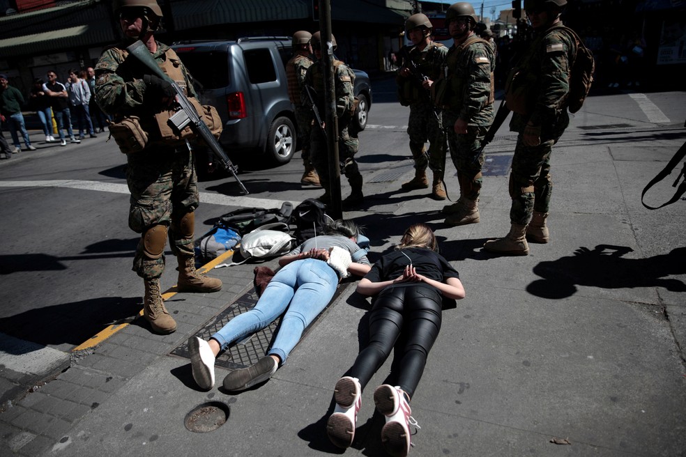 Soldados detêm pessoas suspeitas de terem saqueado lojas em Concepcion, no Chile, em 22 de outubro de 2019 — Foto: Juan Gonzalez/Reuters