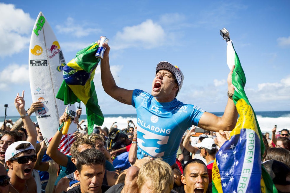 Adriano de Souza, o Mineirinho, é carregado nas areias de Pipeline e vibra muito com o título mundial — Foto: WSL / Kirstin Scholtz